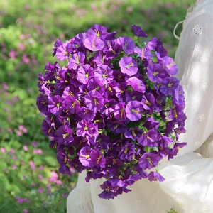 Detailed view of vibrant purple artificial morning glory bouquet in a white lace dress