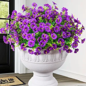 Close-up of purple artificial petunia with eucalyptus in a white stone pot.