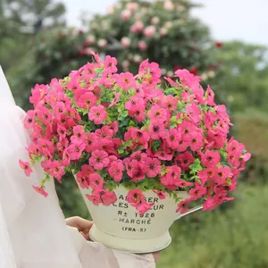 Nahaufnahme von leuchtend rosa künstlichen Stiefmütterchen in einem cremefarbenen Gartentopf