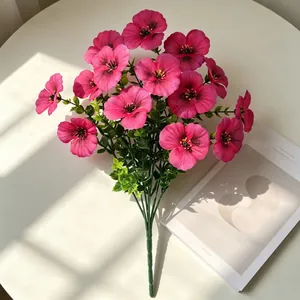 Detailansicht eines künstlichen Stiefmütterchen-Bouquets in Pink auf einem hellen Tisch