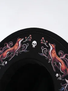 Detailansicht eines schwarzen Filzhutes mit exquisiter Fuchs- und Totenkopf-Stickerei