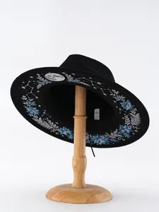 Detailansicht eines schwarzen Gothic-Filzhutes mit Mond- und Blumenstickerei auf der Krempe.