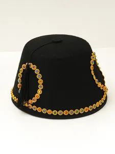 Detailed view of black ethnic felt hat with colorful gemstone trim and black tassel decoration.