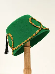 Detailed view of luxury green felt Fez hat with colorful gems and gold tassel trim.