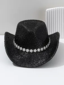 Détail d'un chapeau de cowboy noir pailleté avec une bande de fleurs en strass