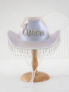 Detailansicht eines irisierenden Cowboyhutes mit Queen-Perlenlogo und Strassfransen.