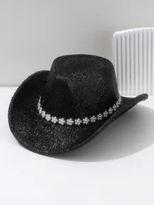 Détail d'un chapeau de cowboy noir à large bord avec bande de fleurs en strass brillant