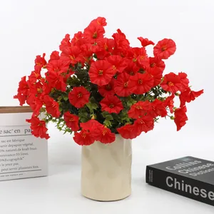Detailed macro shot of vibrant red artificial petunias in a textured beige ceramic vase