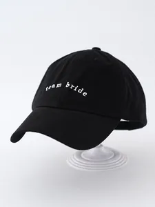 Detailed macro view of a black baseball cap featuring white 'team bride' embroidery on crown