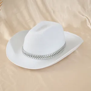 Détail d'un chapeau de cowboy blanc avec bandeau décoratif en strass en forme de feuille