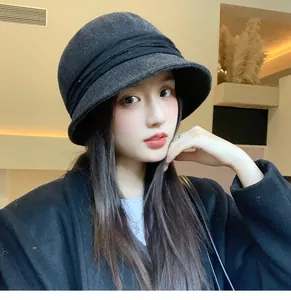 Stylish black Hepburn style pleated wool bucket hat worn by a model in detail