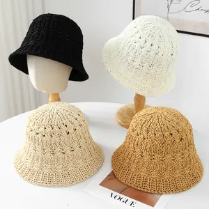 Detailed view of handmade woven straw bucket hats in four various earth-tone colors