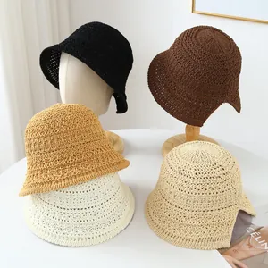Close-up of four handmade breathable straw bucket hats in various earthy tones.