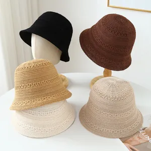 Macro view showing the texture of hand-woven straw bucket hats in different colors
