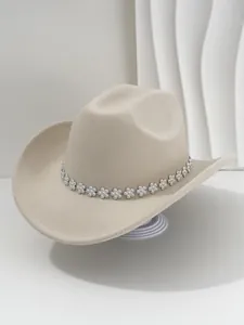 Dettaglio di un cappello jazz western beige di lusso con fascia di fiori in strass.