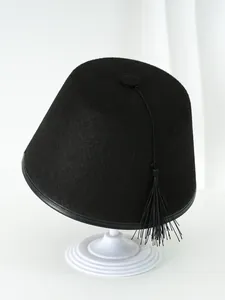 Gorro Fez clásico de fieltro de lana negra con borla larga de seda en soporte de exhibición