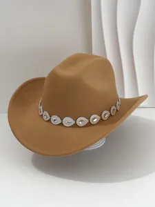 Detail of tan cowboy hat featuring a rhinestone teardrop decorative band.
