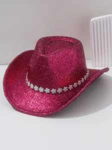 Gros plan d'un chapeau de cow-boy rose scintillant avec un bandeau en strass fleurs.