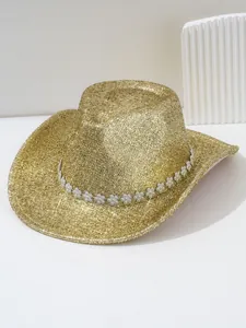 Détail d'un chapeau de cowboy doré à paillettes avec une bande de fleurs en strass.