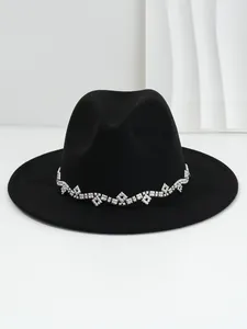 Nahaufnahme eines schwarzen Wollfilzhuts mit elegantem Strassband in Rautenform.