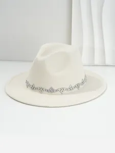 Detailansicht eines cremefarbenen Filzhutes mit einem funkelnden Strass-Diamantband