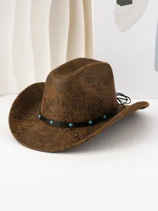 Vue détaillée d'un chapeau de cowboy marron à motif peau de serpent et bande turquoise.