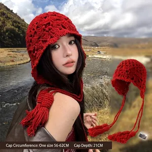 Red handmade hollow crochet knitted beanie hat with stylish tassels for winter