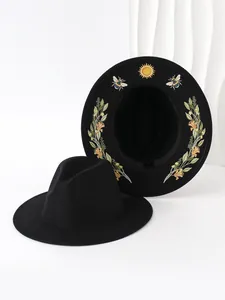 Detailed view of black gothic fedora hats featuring sun and bee embroidery on the inner brim.