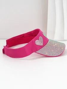 Detail of a hot pink sun visor with sparkling rhinestone heart and studded brim