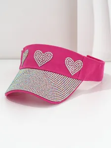 Detailed view of hot pink sun visor featuring sparkling rhinestone hearts and brim.