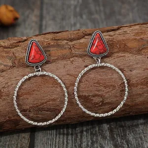 Dettaglio orecchini bohémien vintage con cerchi in argento e pietra turchese rossa sintetica