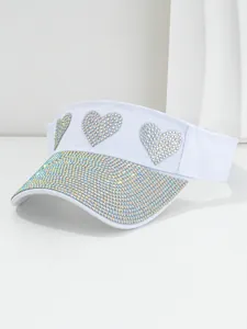 Close-up of white sun visor hat with iridescent rhinestone heart decorations