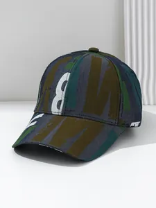Detail showing the abstract letter print and textured fabric of the camouflage baseball cap.