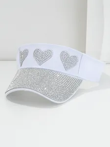 Close-up view of a stylish white sun visor hat with sparkling rhinestone heart details