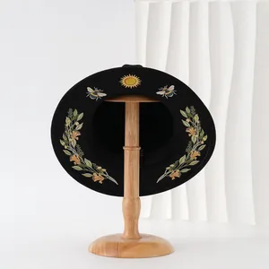 Elegant black gothic flat-brim hat with sun, bee, and floral wreath embroidery-style prints