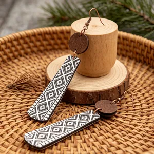 Primo piano di orecchini retrò in legno con motivi geometrici neri e bianchi a rombi.