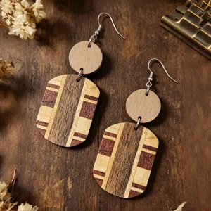 Primo piano di orecchini pendenti in legno bohémien con motivi a strisce multicolori