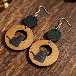 Dettaglio orecchini tondi in legno vintage con silhouette di gatto nero intagliata.