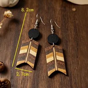 Dettaglio di orecchini vintage in legno a forma di freccia con strisce colorate.