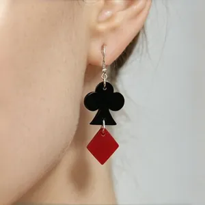 Detailed close-up showing poker club and diamond drop earrings in black and red acrylic
