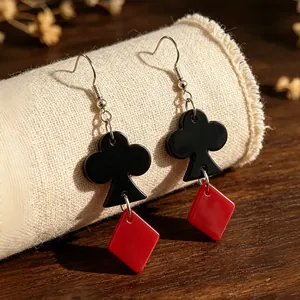 Close-up of black club and red diamond poker earrings made of acrylic material.