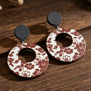 Detail view of vintage wooden hoop earrings with burgundy floral print on white