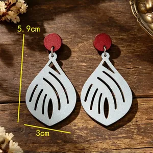 Detailweergave van vintage houten oorbellen in bladvorm met afmetingen 5,9 cm bij 3 cm