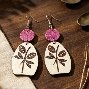 Detalle macro de pendientes de madera retro con círculos magenta y estampado de hojas