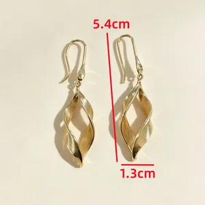 Vista detallada de elegantes pendientes de espiral hueca dorados con dimensión de 5,4 cm
