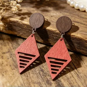 Dettaglio di orecchini geometrici in legno in stile bohémien su sfondo di legno antico