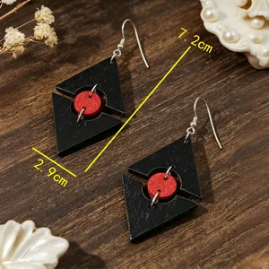 Vista dettagliata degli orecchini geometrici in legno rosso e nero, misura 7,2 cm e 2,9 cm