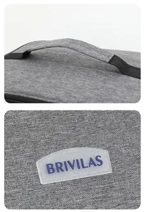Detail van het grijze stoffen handvat en het BRIVILAS-merklogo op de picknicktas.