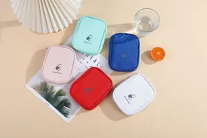 A group of colorful portable medicine storage bags for travel displayed on a desk