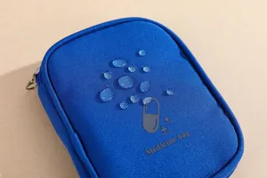 Detailed close-up of blue waterproof portable medicine pouch showing surface water resistance